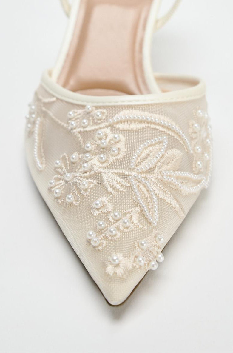 Beige sandal with floral embroidery on a white background